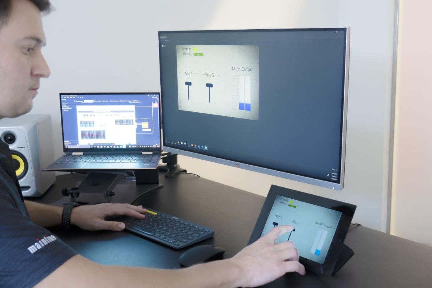 Man configuring an AV touch controller at a workstation
